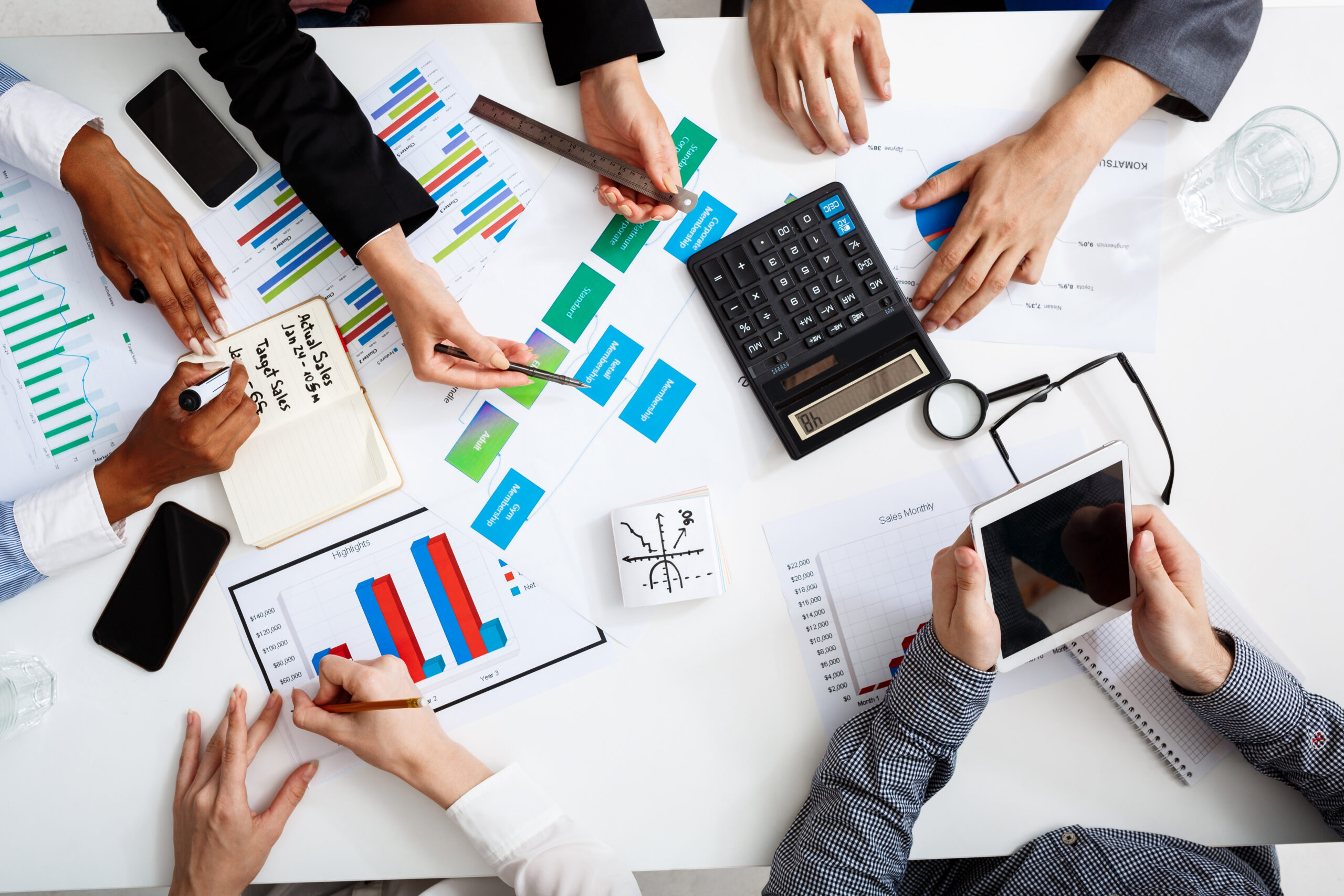 Picture of businessmen’s hands on white table with documents and drafts