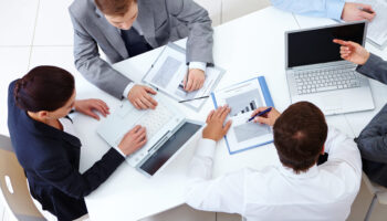 Above view of business team sitting around table and working
